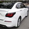 A white sedan with matte smoke tinted taillights and headlights parked on asphalt.