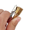 A hand holds a brass tire inflator chuck with a clip-on valve connector.