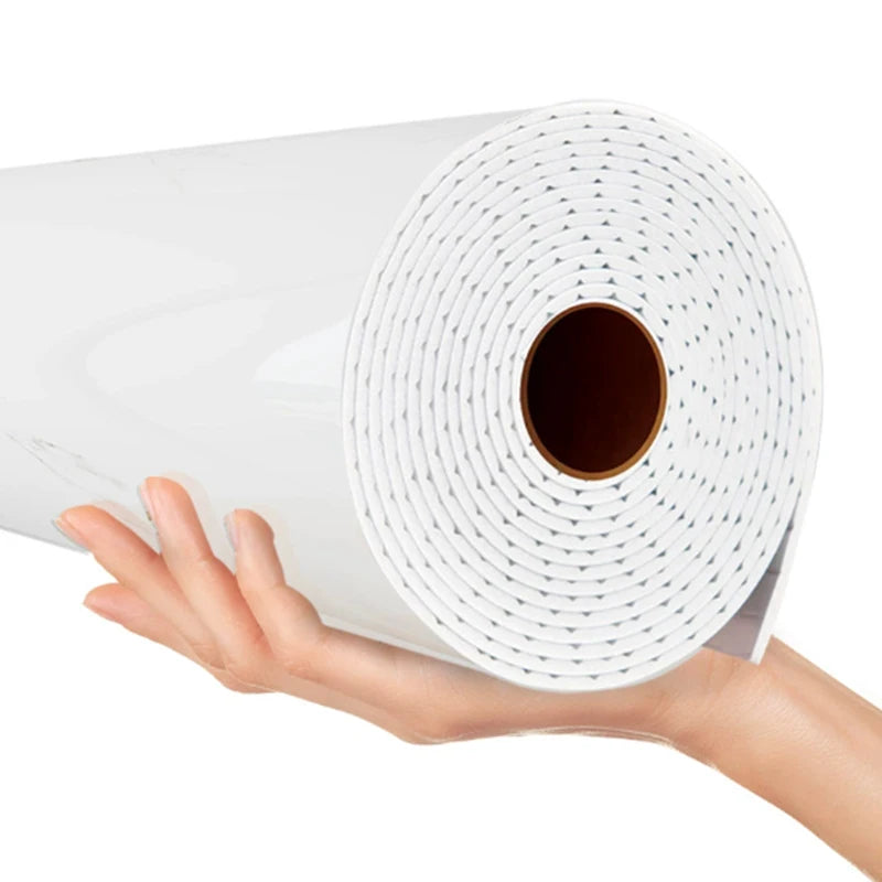 A hand is holding a roll of white self-adhesive marble wallpaper for walls and counters.