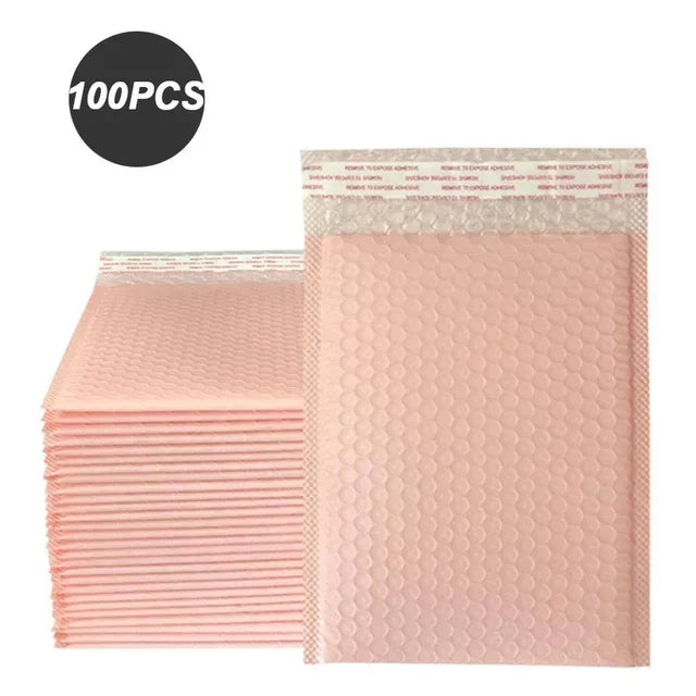 A stack of 100 pink bubble mailers, padded self-seal shipping envelopes.