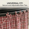 A close-up of a red and white plaid oven skirt with adjustable bow ties hanging on a black rack.