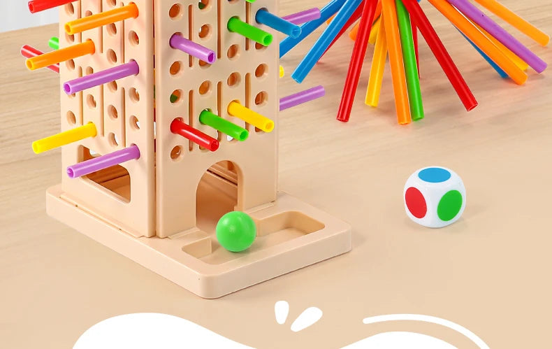 A wooden pick-up sticks board game featuring colorful sticks and a small marble on a light wood surface.