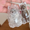 A clear silicone pendant keychain shaped like a fox or small canine is held in a hand.
