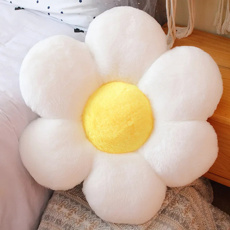 A white and yellow lifelike sunflower plush pillow with soft furry texture resting on a wooden surface.