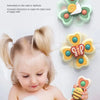 A baby is bathing in foam with insect-themed suction cup bath toys shaped like flowers and bees.