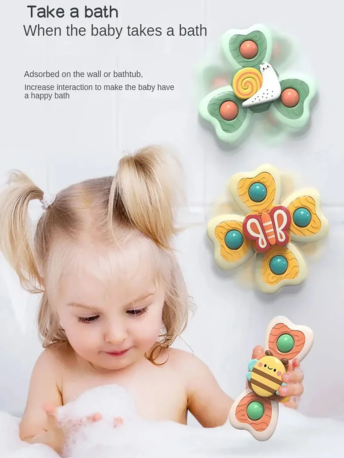 A baby is bathing in foam with insect-themed suction cup bath toys shaped like flowers and bees.
