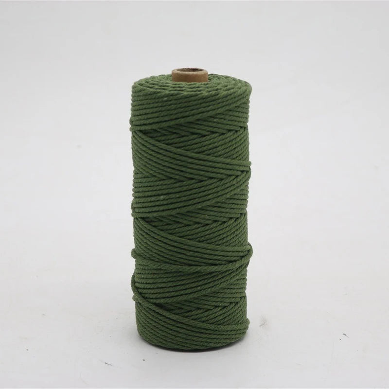 A spool of green macrame cord, 3mm/4mm thickness, used for crafting.