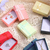 Assorted velvet jewelry gift boxes with cushioned inserts in pink, yellow, and green colors