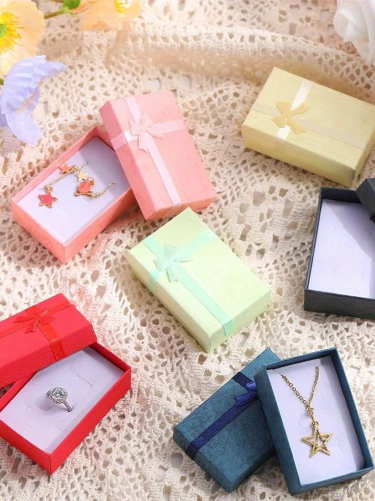 Assorted velvet jewelry gift boxes with cushioned inserts in pink, yellow, and green colors