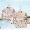 A light pink children's waterproof long sleeve feeding bib with a catch pocket, featuring floral and fruit patterns.