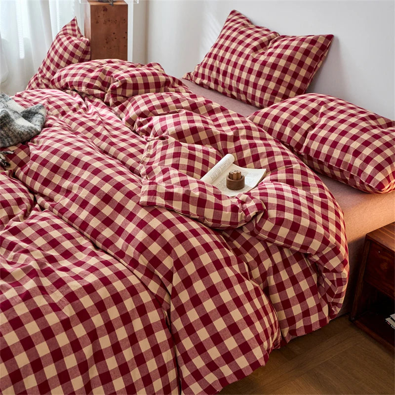 A plaid duvet cover in maroon and beige tones with a checkered pattern, featuring numerous pillows.