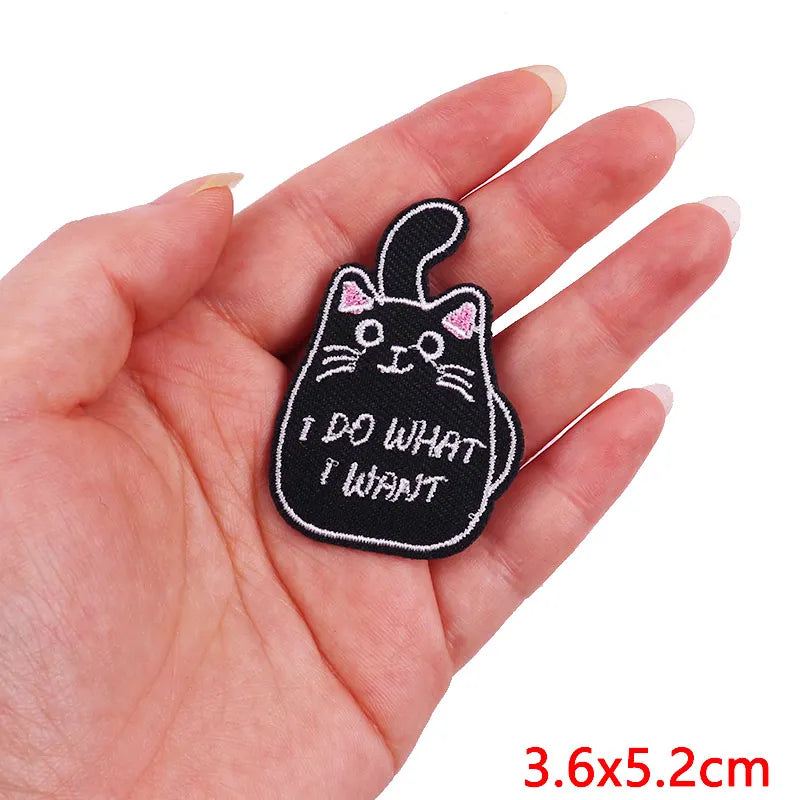 Black embroidery patch of a cat face with whiskers and the text I DO WHAT I WANT on a hand
