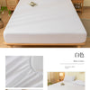 A white fitted sheet with a brushed texture and elastic edge is displayed on a bed.