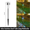 A solar stainless steel tube lamp with multicolor LED lights illuminating a garden path.