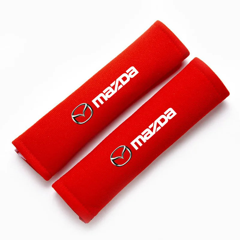 A red soft cotton car seat belt shoulder protector cover rolled up.