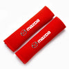 A red soft cotton car seat belt shoulder protector cover rolled up.