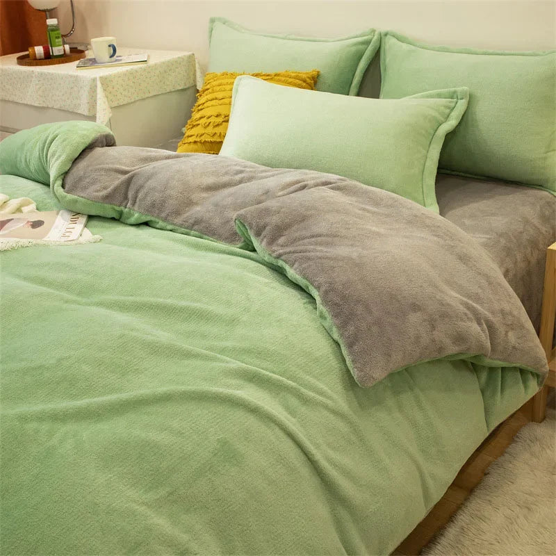 A light green flannel duvet cover with a gray quilted throw and matching pillows on a bed.