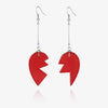 A pair of silver hoop earrings featuring a red stone pendant shaped like a jagged piece.