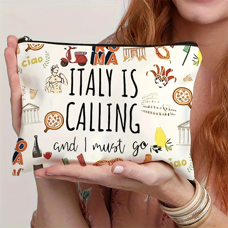 A hand holds an Italian souvenir travel makeup bag with a zipper, featuring text and illustrations.