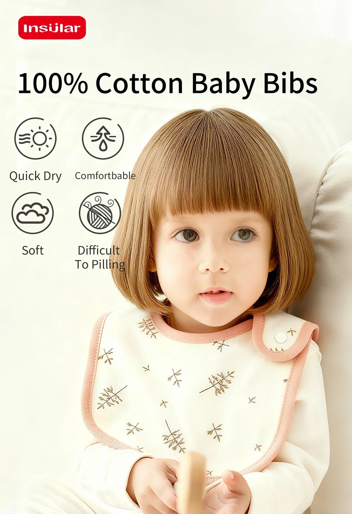 A baby is wearing a white cotton bib with a pink trim, sitting on a light background.