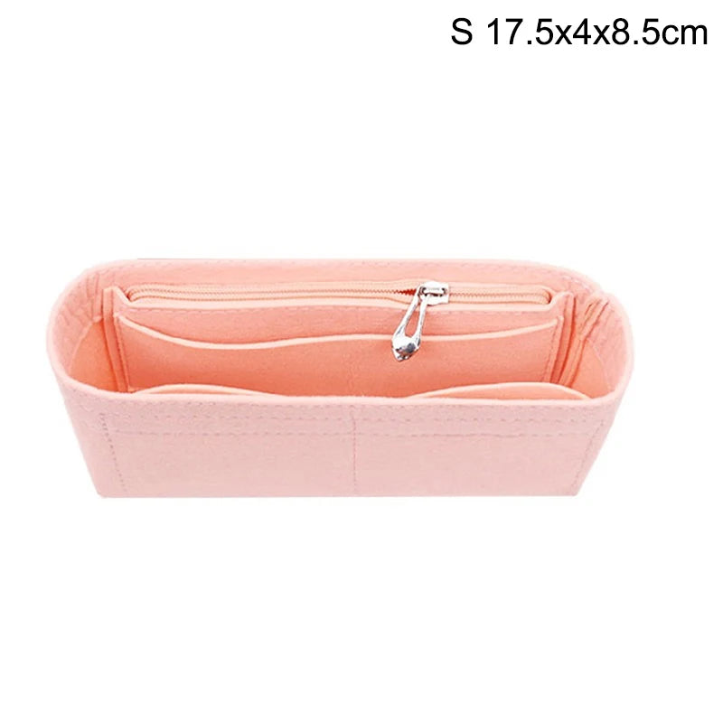A pink felt bag organizer with multiple internal pockets and a zipper closure.