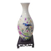 A white ceramic vase shaped like a bird puzzle with floral designs.