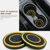 A set of two black and yellow non-slip silicone car cup holder coasters shown in detail.