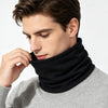 A man wearing a black neck warmer scarf over a gray sweater.