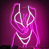 A pink neon silhouette wall sign depicting a female torso outline.
