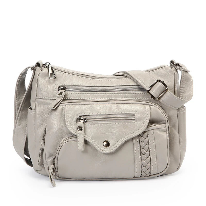 A light beige leather tote bag with a flap closure and adjustable strap.