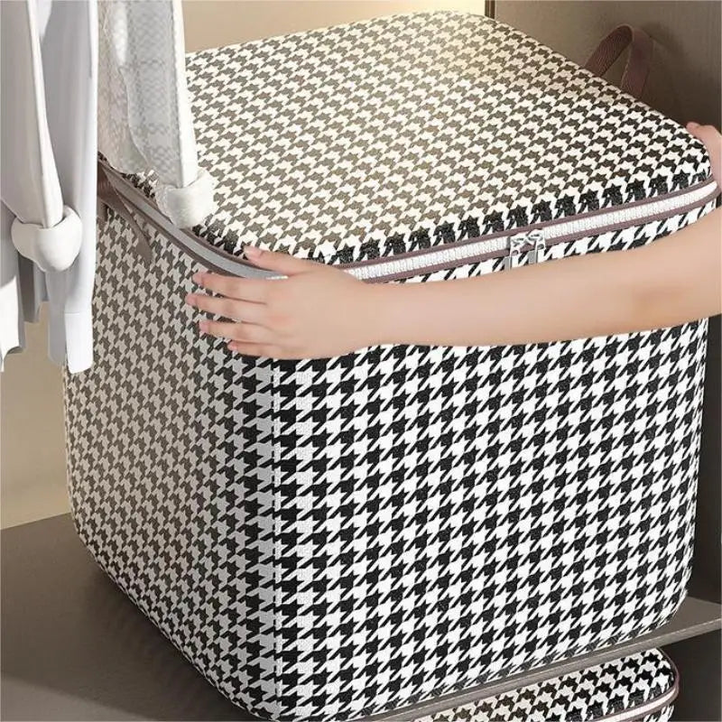 A person is opening a checkered patterned foldable dustproof storage bag for clothes or quilts.