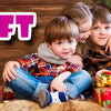 A family of three children sitting on a furry surface with gift boxes and a painting kit displayed.