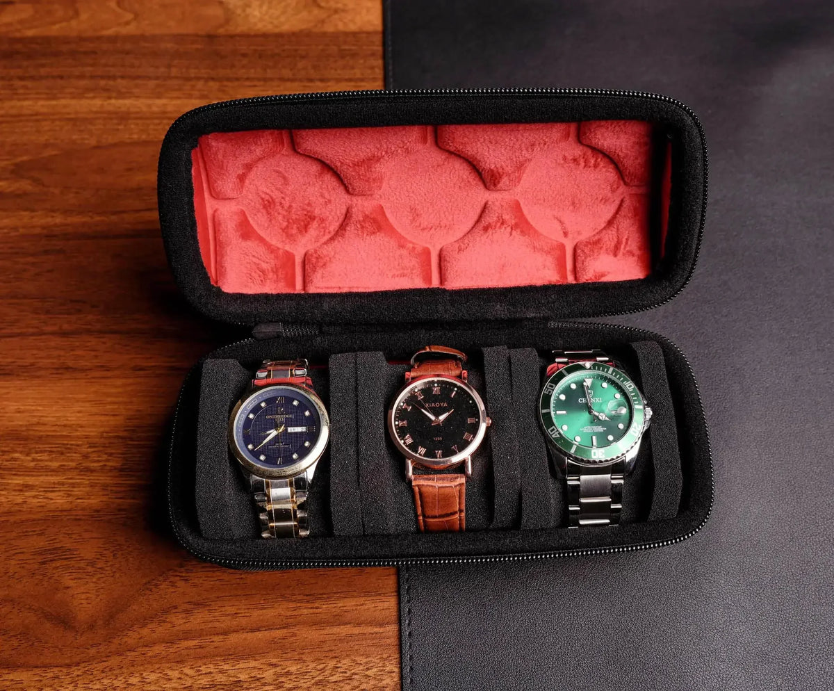 A black watch travel organizer case with a red velvet lining and three watches displayed inside.