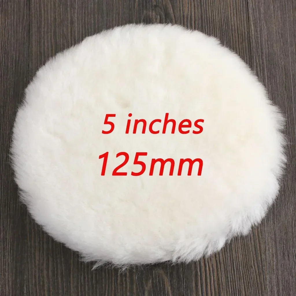 A round white wool polishing pad measuring 5 inches or 125mm resting on a dark wooden surface.