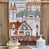 A rectangular embroidered cartoon face towel featuring a cityscape and a house, hanging on a wooden rod.