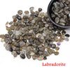 A pile of tumbled labradorite crystal stone chips in various shades of gray and blue.