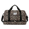Schwarze Leopard-Print-Gepäcktasche mit schwarzen Riemen und Reißverschlussfach.