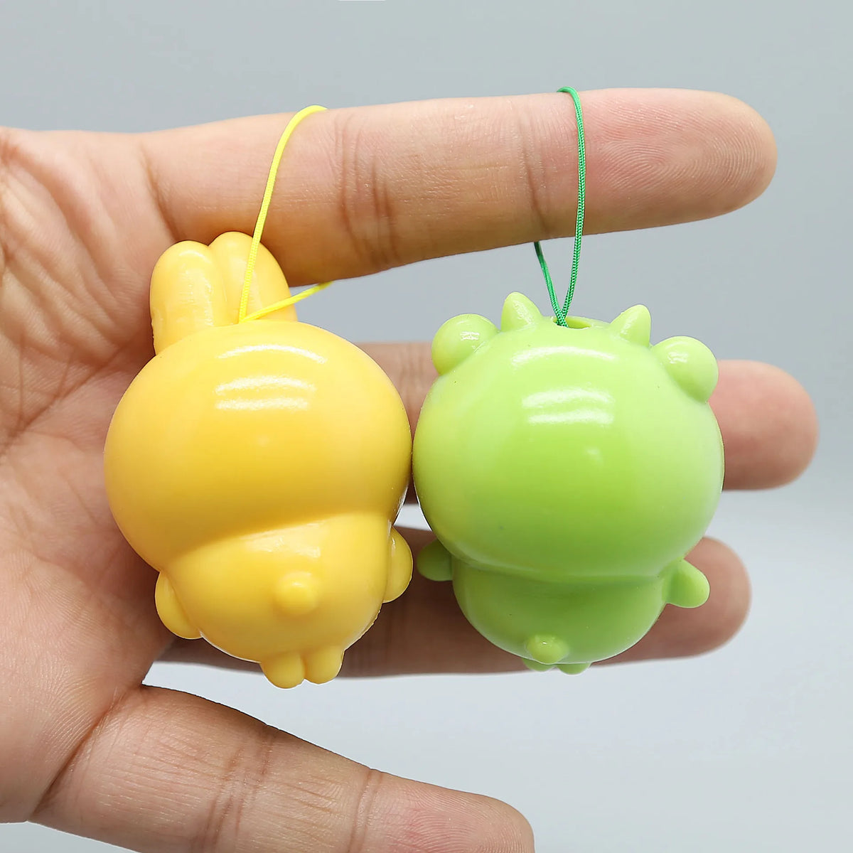 A yellow and green PVC bag pendant doll is held in a hand, featuring an adorable usagi and hachiware design.