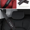 Black leather seatbelt shoulder pad with custom logo stitched onto a red sweater and car seat.