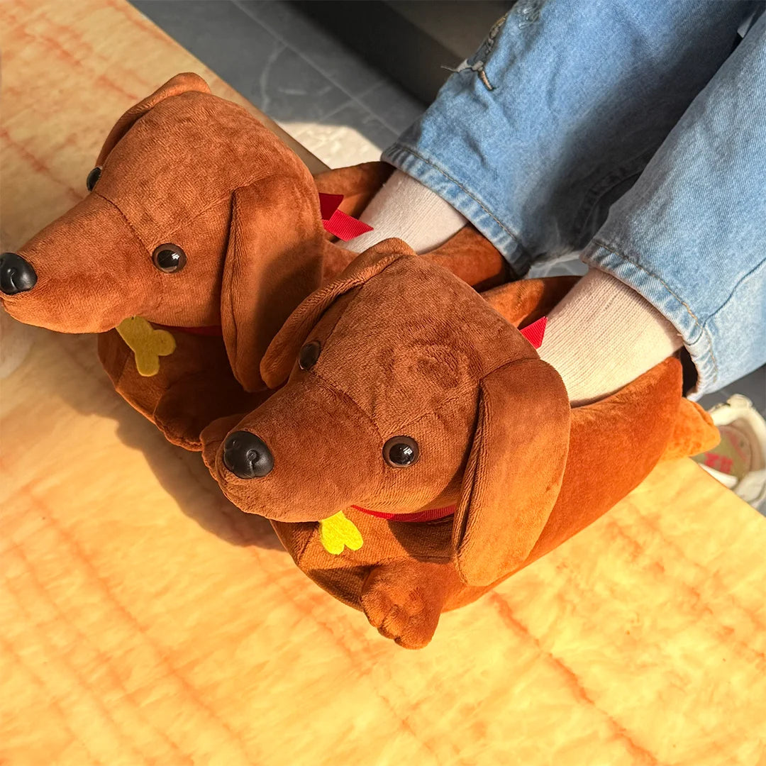 Two brown dachshund plush slippers with yellow accents resting on a wooden surface.