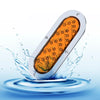 A 6-inch oval LED trailer tail light with a dynamic amber arrow turn signal is shown splashing water.