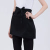A black classic half apron with pockets is shown being worn by a person.