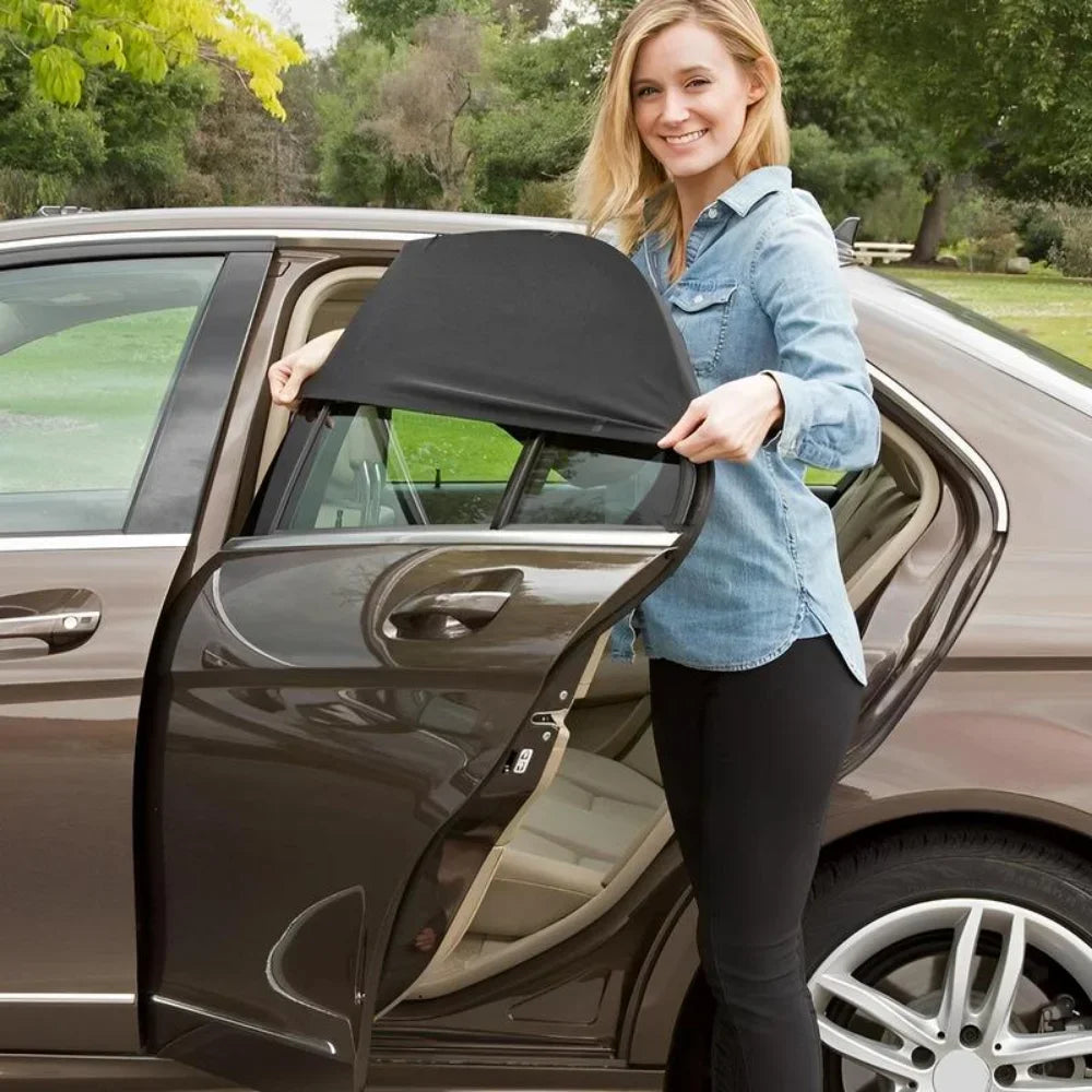 A smiling woman opens the window of a car to install or view a mesh sun shade cover.