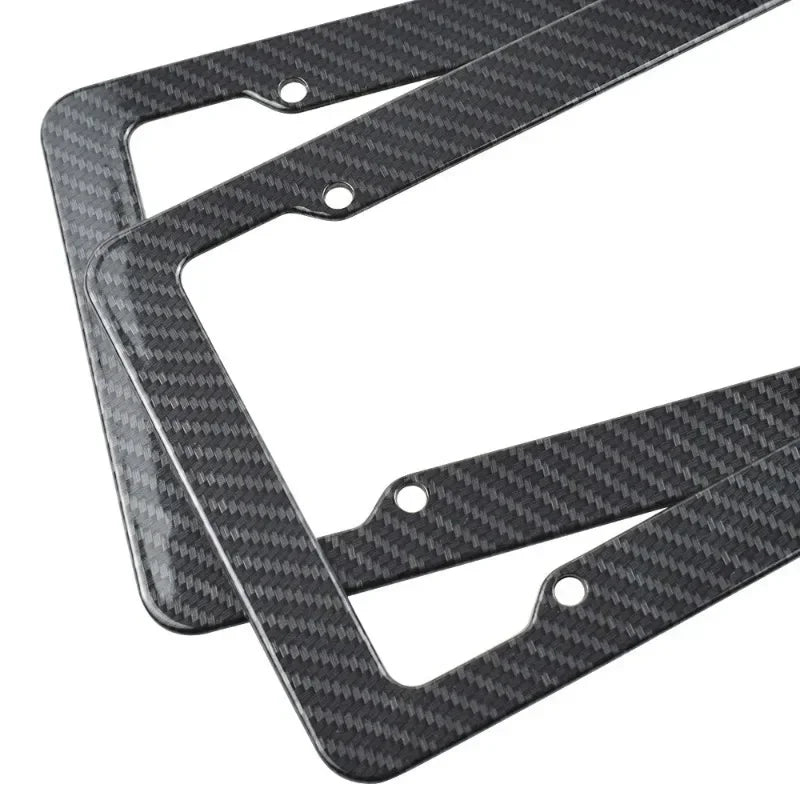 A set of black carbon fiber style license plate frames for front and rear plates.