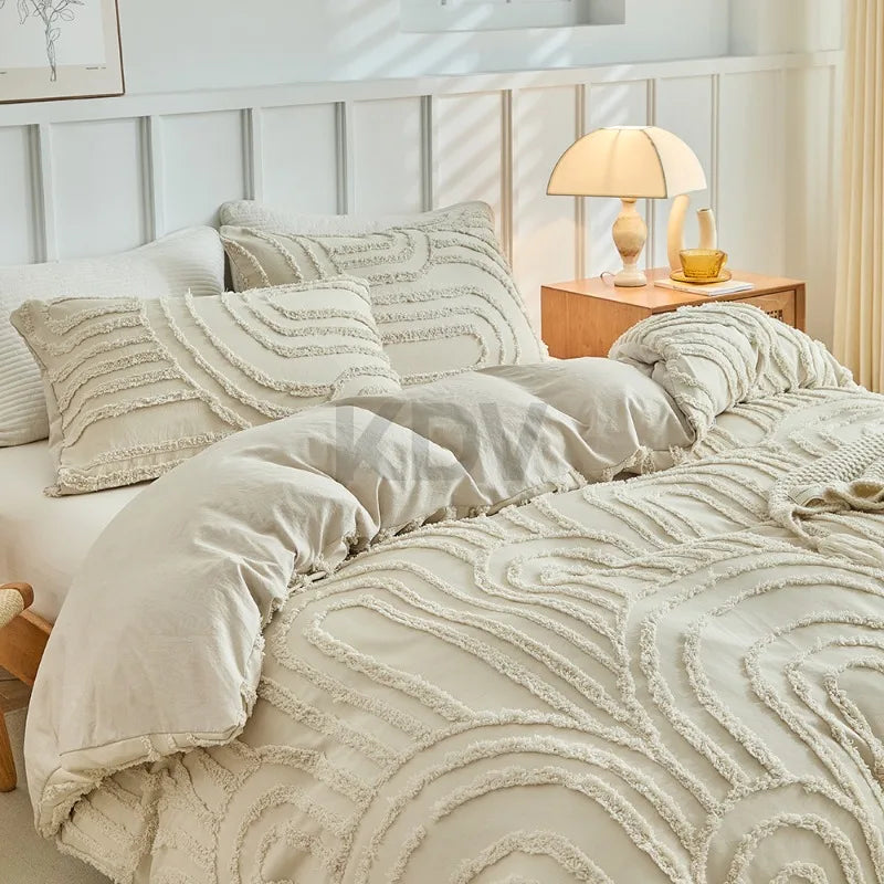 Beige besticktes Blumen-Duvetcover-Set auf einem Bett mit neutraler Bettwäsche und Beistelltisch aus Holz.
