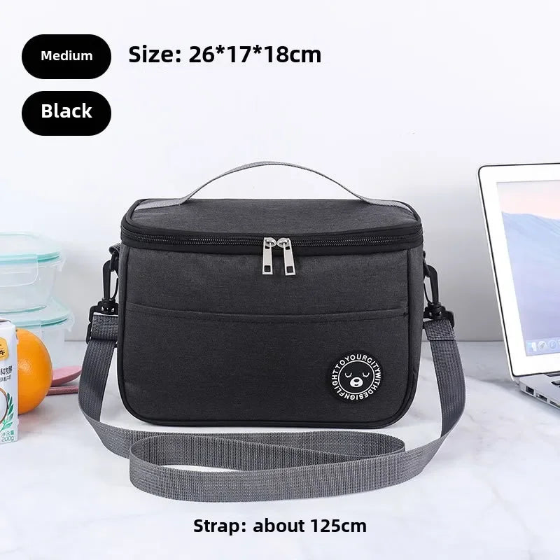Black insulated lunch bag with a shoulder strap shown on a white surface.