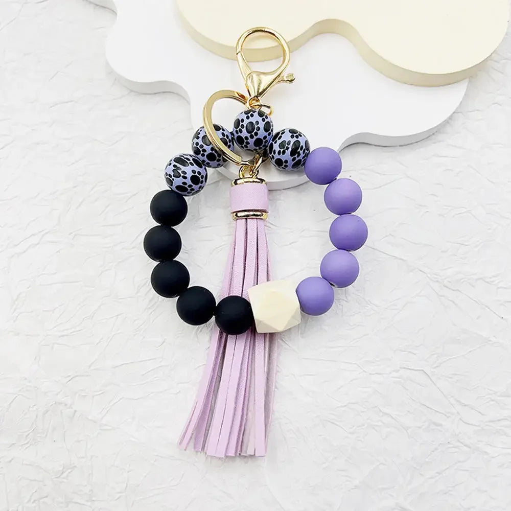Boho silicone bead keychain featuring purple and black beads with a pink tassel