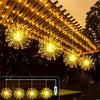 String lights illuminating a wooden pergola with sparkling LED fairy lights hanging from the structure.