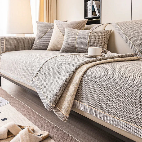 Beigefarbener strukturierter Sofabezug mit hellgrauen Akzenten und Kissen auf einem modernen Sofa.