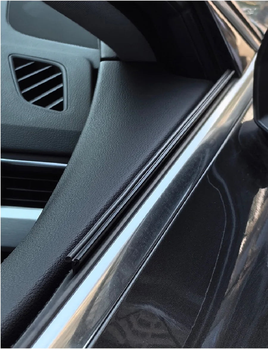 Close-up view of black car side window wiper strips and trim on a vehicle.